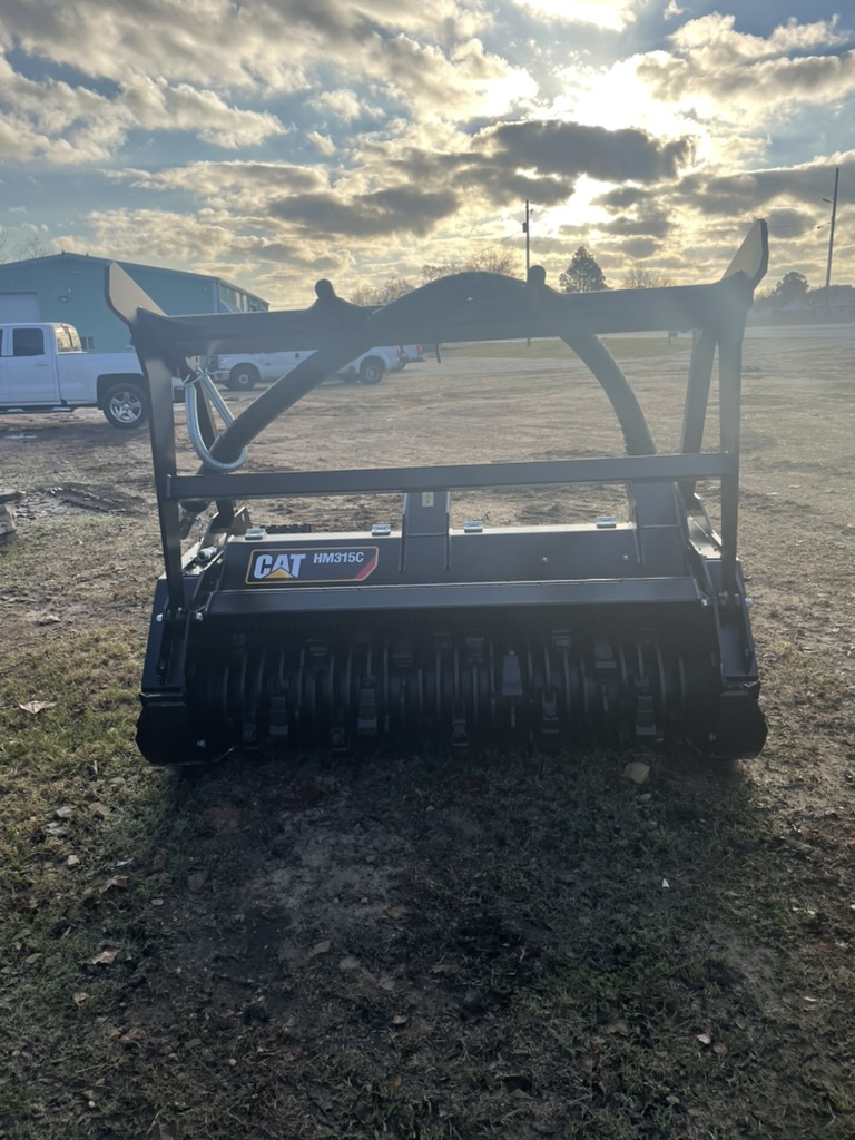 CAT HM315C mulching head attachment with dramatic sky background