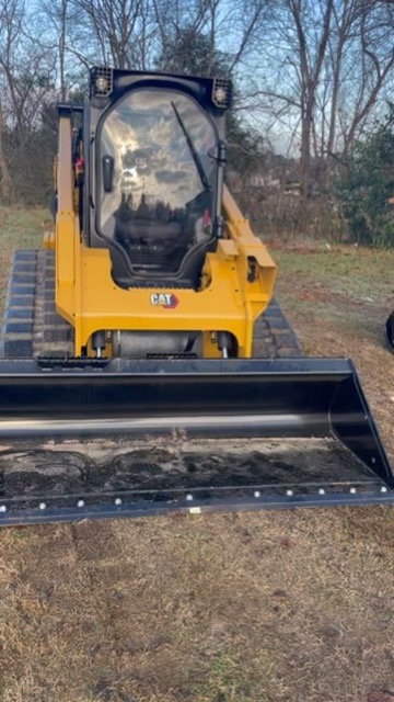 CAT compact track loader front view with grading bucket